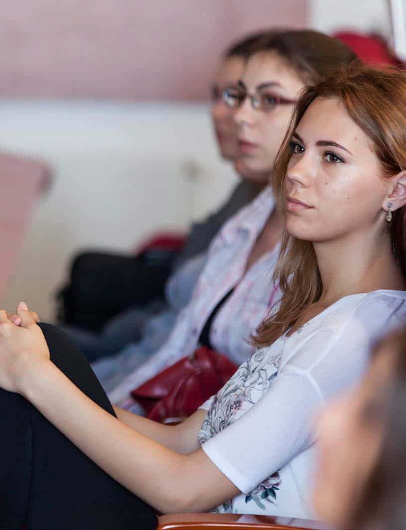 Mehrere Studentinnen sitzen in einer Reihe, sie wirken konzentriert